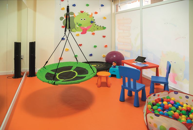 Sala de terapia ocupacional con columpio y elementos de integración sensorial